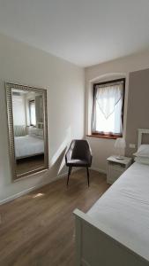 a bedroom with a mirror and a bed and a chair at Sottocastello 1 in Gorizia