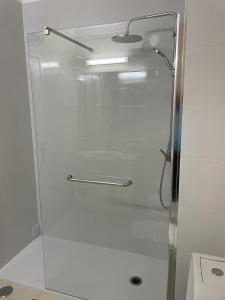 La salle de bains est pourvue d'une douche avec une porte en verre. dans l'établissement Lovely Estrela Vau Apt - Swimming pool view, à Portimão