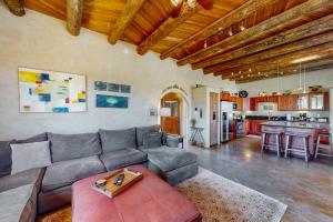 a living room with a couch and a kitchen at Pow Days Taos in Taos