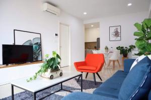 a living room with two blue chairs and a tv at Delightful Apartment - Masteri Millennium - FREE Infinity Pool in Ho Chi Minh City