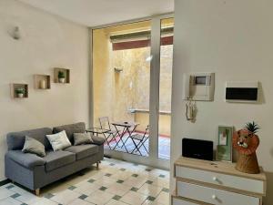 uma sala de estar com um sofá e uma mesa em Lion Home - Appartamento piano terra in piazza em Faenza