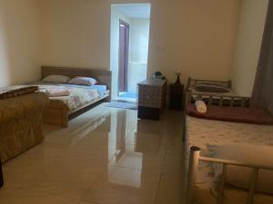 1 dormitorio con 2 camas y puerta a un patio en Backpackers Place - Central Bus Terminal en Abu Dabi