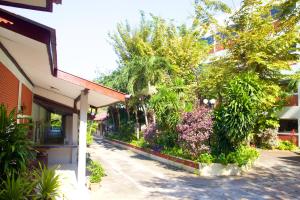 een straat met bomen en planten naast een gebouw bij Sichang Shine Khao Resort in Ko Si Chang