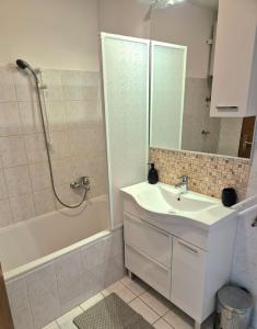 une salle de bain blanche avec lavabo et douche dans l'établissement Apartman Lopar Crikvenica, à Crikvenica