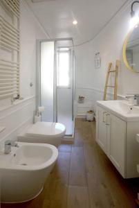 a white bathroom with two sinks and a shower at Residenza al Colosseo in Rome