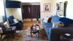 sala de estar con sofá azul y mesa en Home Away from Home - Guest Suite 1 en Red Deer