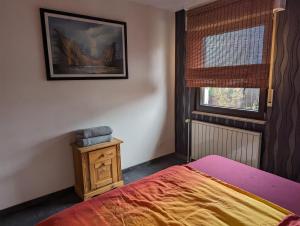 1 dormitorio con 1 cama y una foto en la pared en Ferienwohnung Waldrand am See, 