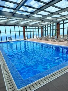 una gran piscina con sillas en un edificio en 2H Hotel en Orán