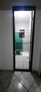 a door to a bathroom with a shower and a toilet at Pouso da Praça in Bonfim