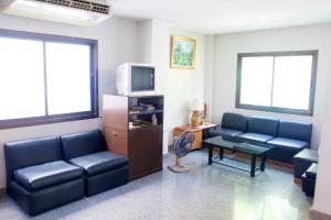 a living room with two couches and a tv at Sichang Shine Khao Resort in Ko Si Chang