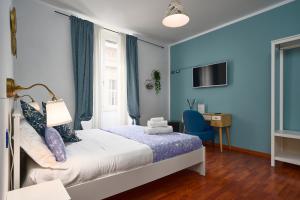 a bedroom with blue walls and a bed and a desk at Hotiday La Spezia Quiet Night in La Spezia