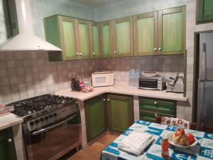 een keuken met groene kasten en een fornuis bij Villa Rosa in Santa Caterina