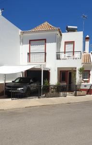 een auto geparkeerd in de garage van een wit huis bij Casa Família Cardoso in Tavira