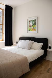 1 dormitorio con 1 cama con sábanas blancas y ventana en Luxury In Transit Rasco, en Montreal