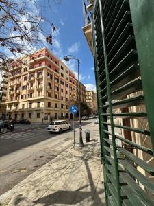 una macchina bianca è parcheggiata in una strada accanto a un edificio di Villafranca settantuno Apartments a Palermo