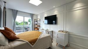 a bedroom with a bed and a television in it at 23- Studio Luxo Perfeito in Curitiba