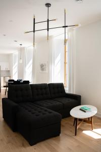 a living room with a black couch and a table at La Maison Rasco in Montréal