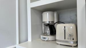 a coffee maker and a blender sitting on a shelf at 23- Studio Luxo Perfeito in Curitiba
