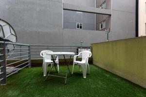 a table and chairs on a balcony with green grass at Gente del Sur - Godoy in Ushuaia