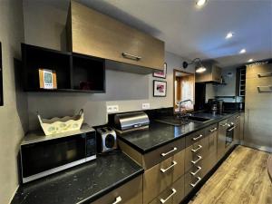 a kitchen with a counter top with a microwave at Résidence L'escarel - Chalet mitoyen à 150m du téléski MAE-4051 in Saint-Martin-de-Belleville +13 photos