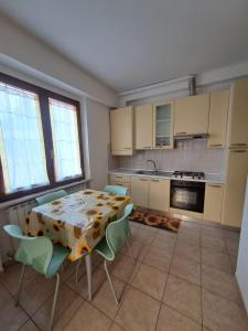 une cuisine avec une table et des chaises ainsi qu'une cuisine avec une cuisinière dans l'établissement La Casa dei Girasoli, à Castelfidardo