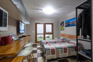 a room with two beds and a desk at Gente del Sur - Godoy in Ushuaia