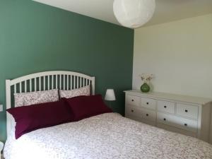1 dormitorio con cama blanca y almohadas moradas en Location proche plage de Penvins, Sarzeau, en Sarzeau