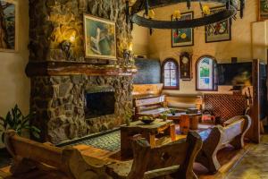 una gran sala de estar con chimenea de piedra. en Hostería La Posta Del Cazador en San Martín de los Andes