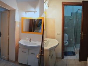 a bathroom with a sink and a toilet and a mirror at Ostello Marello in Rome