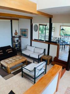 a living room with couches and tables and chairs at Preciosa Casa con Piscina y muelle en orilla Lago Rapel in Las Cabras