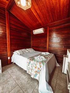 a bedroom with a bed in a wooden wall at Village dos Pássaros in Belo Oriente +33 photos