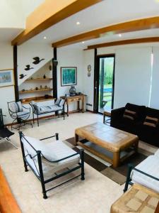 a living room with couches a couch and a table at Preciosa Casa con Piscina y muelle en orilla Lago Rapel in Las Cabras