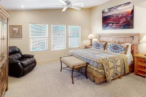 a bedroom with a bed and a chair and a ceiling fan at Rim Village U4 in Moab