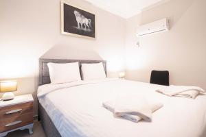 een slaapkamer met een groot wit bed, een nachtkastje en een bureau bij Dedeminn Garden Hotel in Göcek