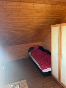 a small room with a bed in a wooden cabin at Nimród apartman in Gabčíkovo