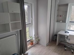 a room with a desk and a window with a desk and a computer at Słońce Bemowa in Warsaw