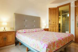 a bedroom with a large bed with a floral bedspread at Waterfront villa with breathtaking views and pool in Colera