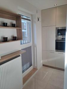 a kitchen with white cabinets and a window at Słońce Bemowa in Warsaw