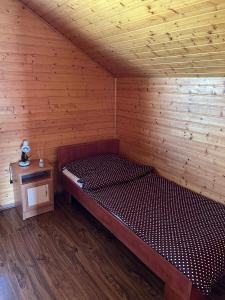 a wooden cabin with a bed in a room at Nimród apartman in Gabčíkovo