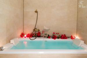 a bath tub with red flowers in a bathroom at Waterfront villa with breathtaking views and pool in Colera +35 photos