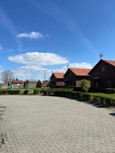 a brick driveway with a playground in the background at Nimród apartman in Gabčíkovo