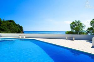 a swimming pool with the ocean in the background at Waterfront villa with breathtaking views and pool in Colera