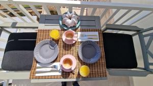 une table avec des assiettes et des tasses de café sur un balcon dans l'établissement Vila Luka 2, à Hvar