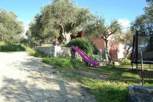 a house with a purple slide in a yard at Taki's & Anna's in Levkóyia