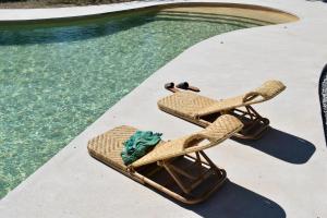 - une paire de chaises de plage à côté de la piscine dans l'établissement Villa Alexandra, à Patmos