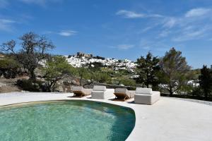 a swimming pool with lounge chairs and a mountain at Villa Alexandra in Patmos