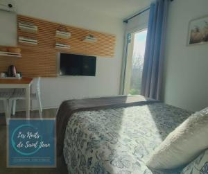 Un dormitorio con una cama con un cartel. en Les Nuits de Saint Jean, en Saint-Jean-Saint-Maurice-sur-Loire