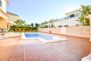 una casa con piscina en un patio en Vila com piscina a 5 minutos da Praia, en Alcantarilha