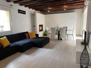 - un salon avec un canapé noir et une table dans l'établissement Ca' Del Vecio, in centro storico, Piazza Garibaldi, à Bassano del Grappa