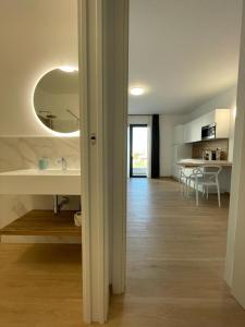 Baño blanco con lavabo y espejo en Residence Cala Bianca, en Porto Torres